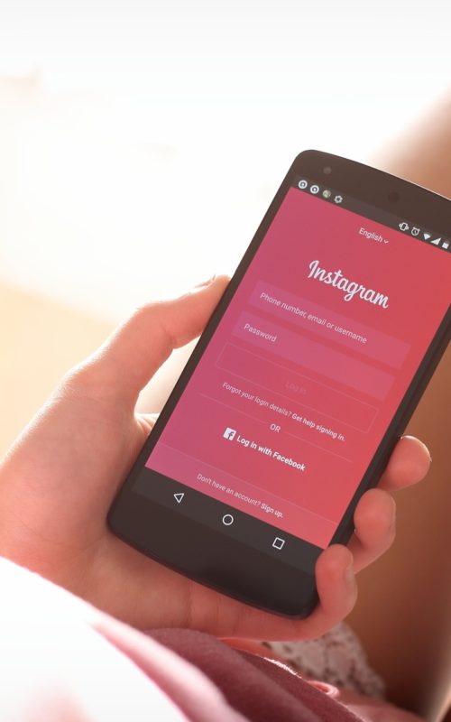 Woman holding iphone showing Instagram log in screen